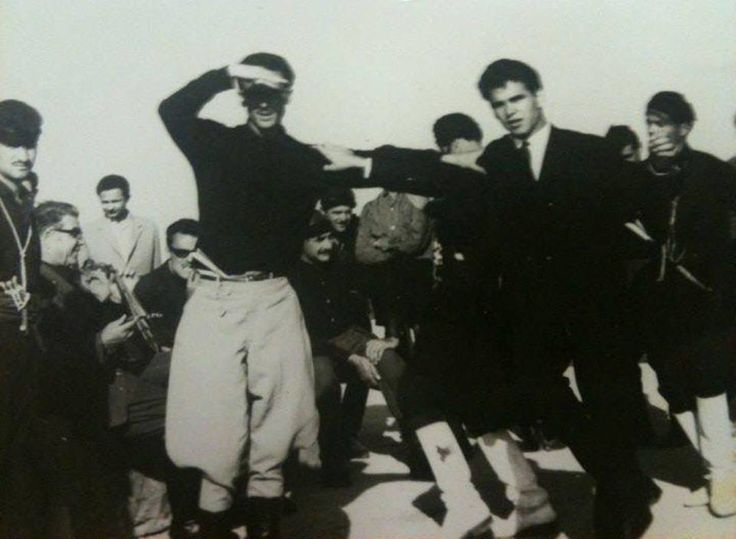 “Στον ουρανό χορεύγουνε, στον Άδη κάνουν γάμο”: Μια συλλεκτική φωτογραφία από το 1964. O Nίκος Ξυλούρης χορεύει με τον Βασίλη Σκουλά, υπό τους ήχους της λύρας του Δερμιτζογιάννη