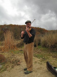 Chris playing violin by Lake Zaravina photo by Vassilis Georganos - Ο Chris παίζει βιολί δίπλα στη λίμνη Ζαραβίνα, φωτογραφία από Βασίλη Γεωργάνο